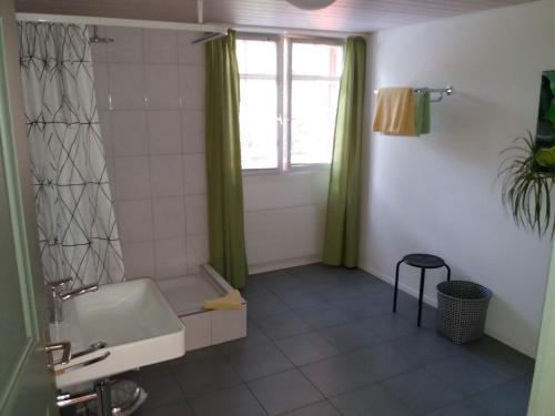 ein Bad mit einem WC, einem Waschbecken und einem Fenster in der Unterkunft Hotel Garni Frohsinn in Uttwil