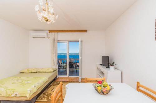 a bedroom with a bed and a balcony with the ocean at Apartments Karalic in Crikvenica