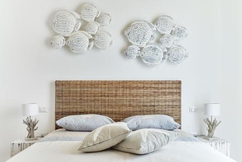 a bedroom with a bed with plates on the wall at POSEA - Polignano Sea Suites in Polignano a Mare