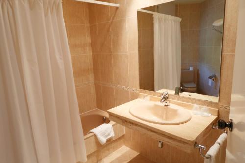 a bathroom with a sink and a shower curtain at Hotel O Camiño in O Barco de Valdeorras