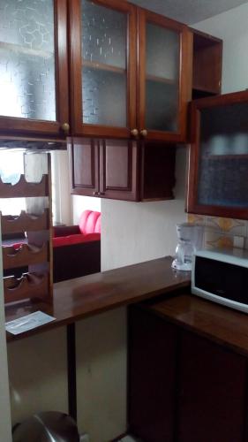 a kitchen with wooden cabinets and a desk with a laptop at Apartment business/airport area Guatemala City in Guatemala