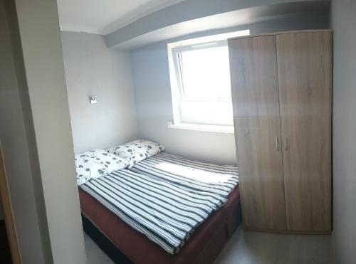 a small bedroom with a bed and a window at Noclegi nad Soliną in Solina