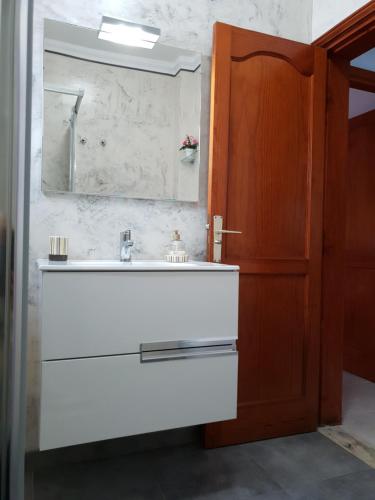 a bathroom with a white sink and a mirror at Ayfa Apartment in Punta de Mujeres