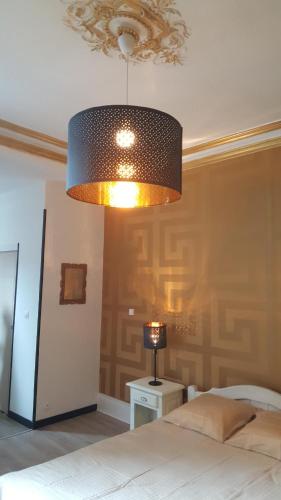 a bedroom with a bed and a lamp on a table at Luxury Suite Lilas in Dijon