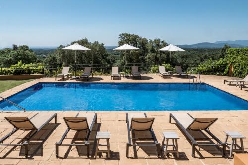 ein Pool mit Chaiselongue und einem Haufen in der Unterkunft Hotel Can Xiquet in Cantallops