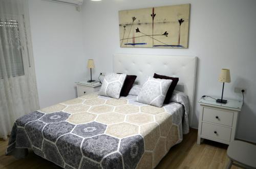 ein Schlafzimmer mit einem Bett und zwei Nachttischen in der Unterkunft Apartamento Cervantes in Fuengirola