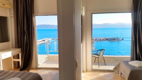 a bedroom with a view of the ocean from a balcony at Porto Evia Boutique Hotel in Amarinthos