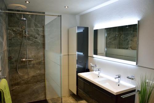ein Bad mit einem Waschbecken und einer Dusche in der Unterkunft Apart Belvita in Sankt Leonhard im Pitztal