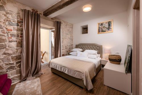a bedroom with a large bed and a large window at Hotel Agava Split in Split