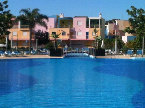 uma grande piscina azul com edifícios ao fundo em APARTAMENTOS DA ORADA, G 014 em Albufeira