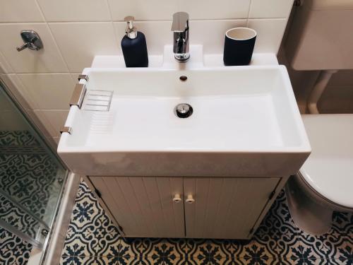 een witte wastafel in een badkamer met een toilet bij West vibes apartment in Zagreb