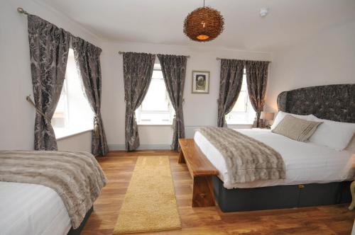 a bedroom with two beds and two windows at Lodge at The Old Barracks in Athenry
