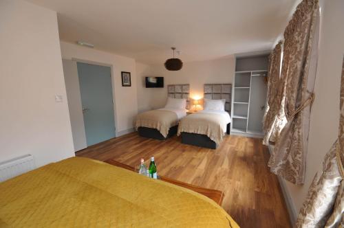 a bedroom with two beds and a wooden floor at Lodge at The Old Barracks in Athenry
