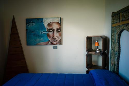 a bedroom with a painting of a woman on the wall at Paradiso verde a poca distanza dal mare in Agropoli