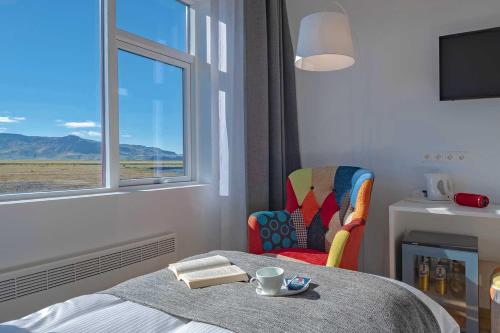 a bedroom with a table and a chair and a window at Hotel Selja in Hvolsvöllur