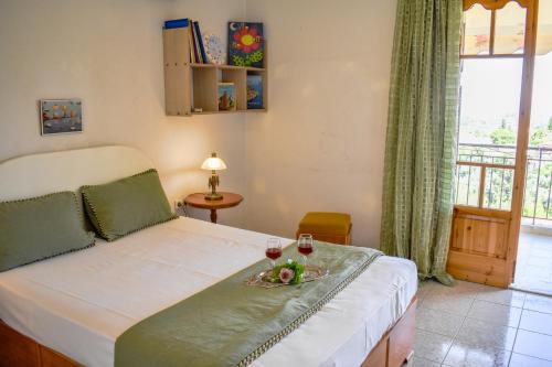 a bedroom with a bed with two glasses of wine at Mayra Apartment in Lithakia