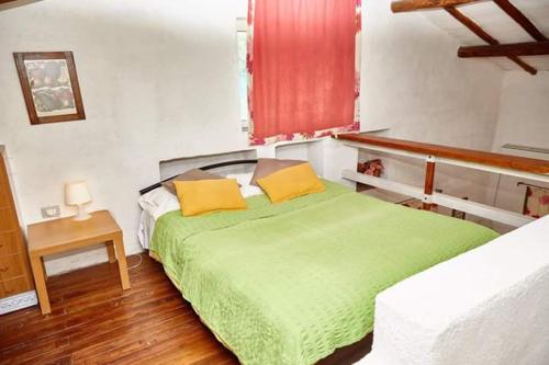 a bedroom with a green bed and a window at Borgo S.Maria Di Vulci in Montalto di Castro