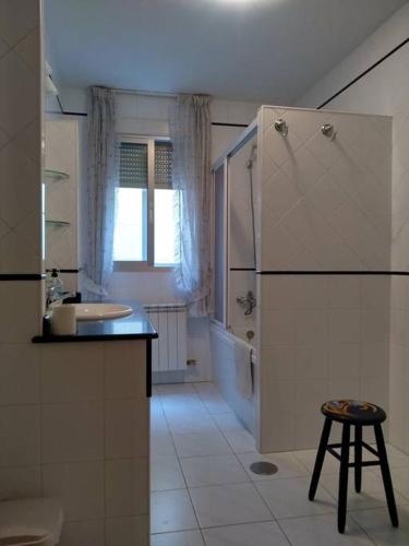 a bathroom with a sink and a shower and a stool at Pilar Villanueva in Bueu