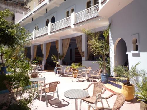 un patio avec des tables et des chaises en face d'un bâtiment dans l'établissement Dar Omar Khayam, à Tanger