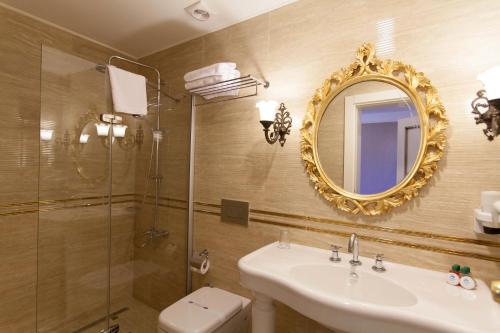 a bathroom with a sink and a shower and a mirror at Aspen Hotel Kaleiçi in Antalya