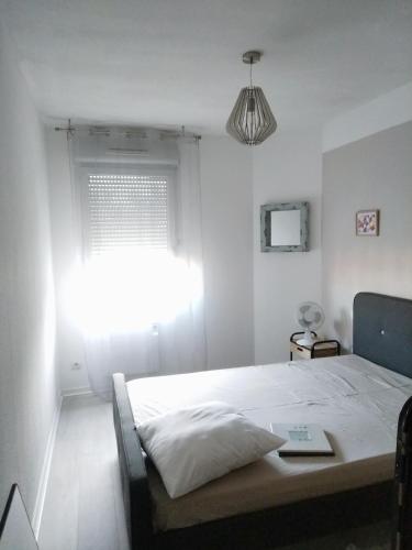 une chambre blanche avec un lit et une fenêtre dans l'établissement T3 Bonnefoy, à Toulouse