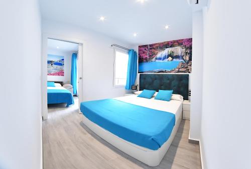 ein Schlafzimmer mit einem großen Bett mit blauer Bettwäsche in der Unterkunft Zenmarina 614 playa carihuela in Torremolinos