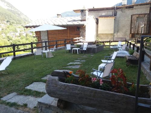 a garden with chairs and tables and a building at Hotel Ottoz Meublé in Courmayeur