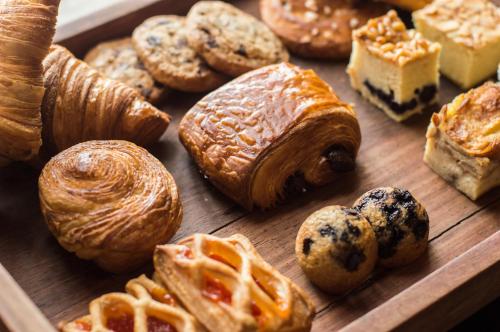 a wooden tray filled with different types of pastries at Casa Malca in Tulum