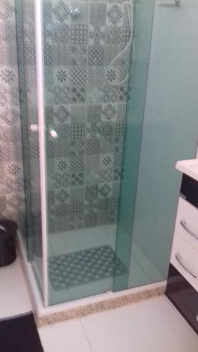 y baño con ducha y puerta de cristal. en Casa da Celia, en Arraial do Cabo