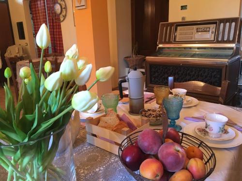 a table with a bowl of fruit and flowers on it at Locanda della Lavanda in San Clemente