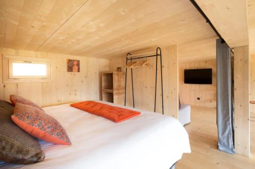 a bedroom with a bed in a wooden cabin at Les Lodges, by Refuges en ville in Bourg-Saint-Maurice
