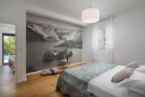 Villa Diana في قشتيلا: غرفة نوم بها سرير كبير ولوحة فنية على الحائط