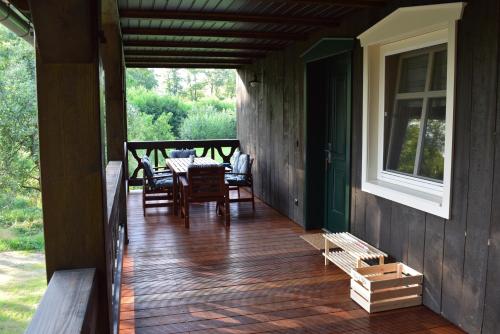 a porch of a house with a table and chairs at Adelinenhof - Ferienapartments, Fasten, Wellness & Gesundheit in Burg