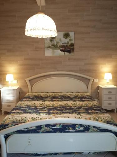 1 dormitorio con cama y lámpara de araña en A casa di Arianna, en Portoferraio