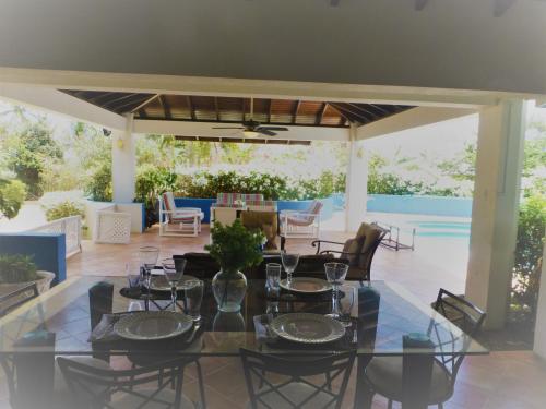 a dining room with a table and chairs on a patio at Coral Villa in Saint Philip