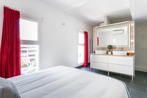 a white bedroom with two sinks and a red curtain at Luxury Penthouse in Naturiste; FKK, Nudist Village in Cap d'Agde