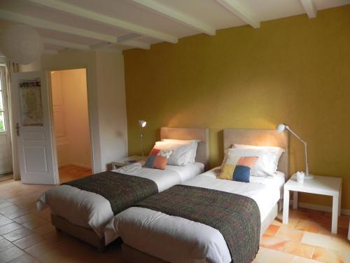 two beds sitting next to each other in a room at Au Son du Jardin Poitevin in Saint-Laurs