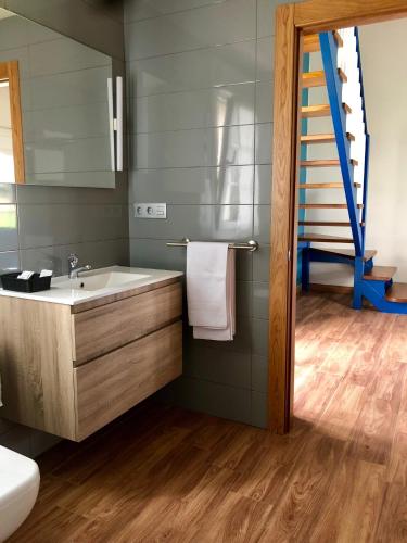 a bathroom with a sink and a staircase at Playas de Luarca in Barcia