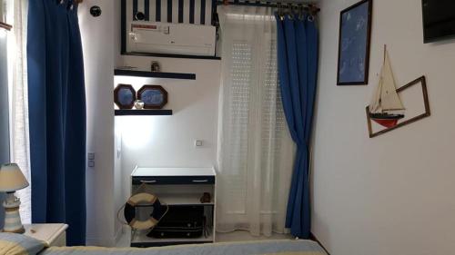 a living room with blue curtains and a room with a bed at En Marina D'Or primera linea real in Oropesa del Mar