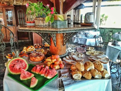 um buffet de comida numa mesa com frutas e produtos de pastelaria em Pousada das Palmeiras em Camanducaia