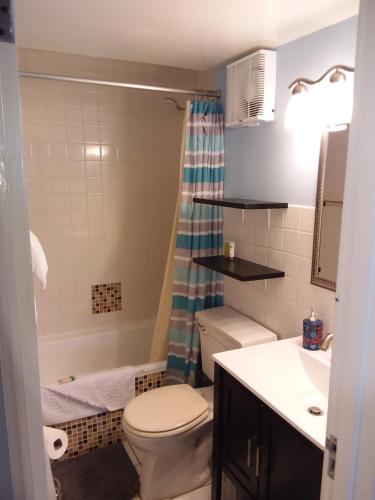 a bathroom with a toilet and a tub and a sink at McFarlane's Place in Ocho Rios