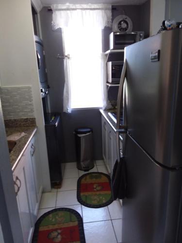 a kitchen with a stainless steel refrigerator and a window at McFarlane's Place in Ocho Rios