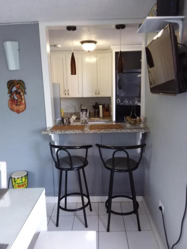 a kitchen with a counter and two bar stools at McFarlane's Place in Ocho Rios