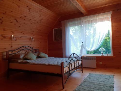 1 dormitorio con 1 cama en una habitación con ventana en Roguļi en Cērkste