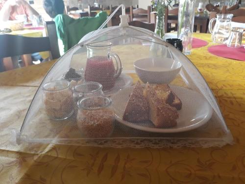 - une table avec une assiette de nourriture et des verres dans l'établissement Agriturismo Campo Rosso, à Civitella di Romagna