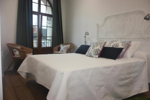 a bedroom with a large white bed with pillows on it at La Casa de Loli in Luarca