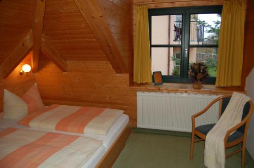 1 dormitorio con 2 camas, silla y ventana en Appartementhäuser am Gothensee, en Bansin