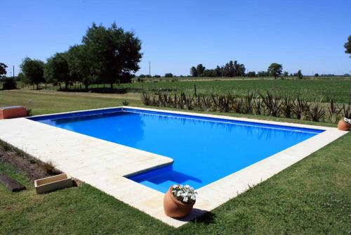 una piscina azul en medio de un campo en Hostería Rural Les Aldudes en San Andrés de Giles