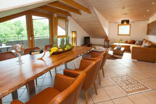 a living room with a large wooden table and chairs at Residenz Cheval am Pfaffenberg Friedrichshafen Messe in Oberteuringen
