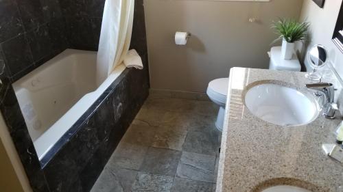 a bathroom with a tub and a sink and a toilet at Gondola Lodge & Tahoe Beach Club in South Lake Tahoe